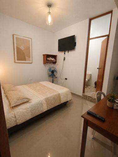 a bedroom with a bed and a flat screen tv at Hospedaje Cocos House Talara - amplias habitaciones, Buena Ubicacion in Talara