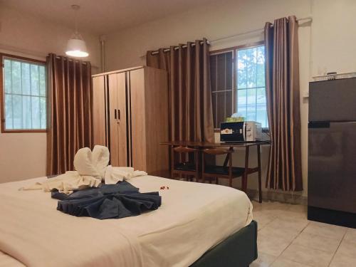 a hotel room with a bed and a desk and windows at Little house in Koh Samui