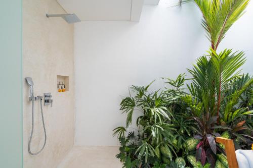 a bathroom with a shower with plants in it at Villa Camille - Private 1BR Oasis with Pool in Nyanyi Beach in Tanah Lot