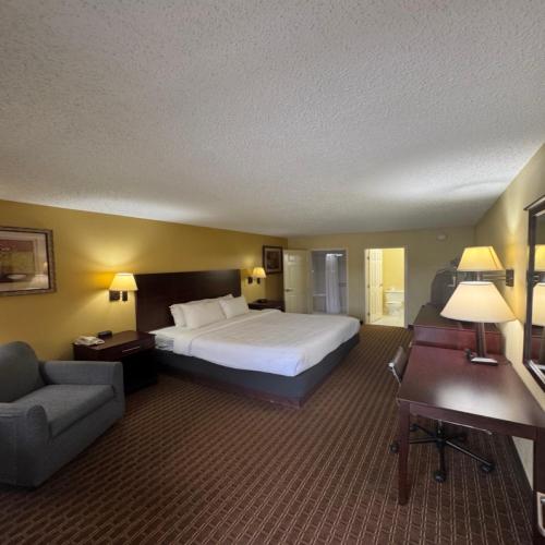 a large hotel room with a bed and a couch at Quality Inn Franklin South in Franklin