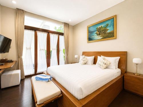a bedroom with a large white bed and a window at D'Avera Villa Canggu in Canggu