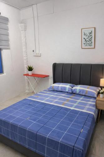 a blue bed in a room with a red table at DNH Nilam Puri Homestay Unit C in Kota Bharu