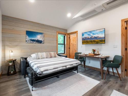 a bedroom with a bed and a desk in it at Alpenhaus | Ski Jackson & Targhee in Victor