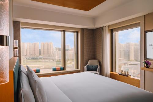 a bedroom with a large bed and a large window at Hotel Okura Macau in Macau