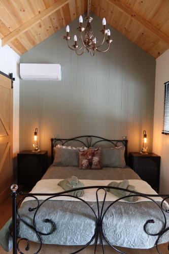 a bedroom with a bed with a chandelier at Amoré Cabin in Ocean View