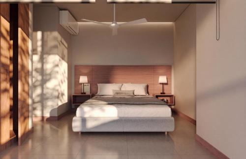 a bedroom with a large bed and two lamps at Nuruma Suites by Avia Suites in Santa Marta