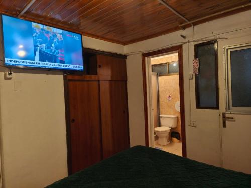 a bedroom with a flat screen tv on the wall at Hostal Gomero in Santa Cruz
