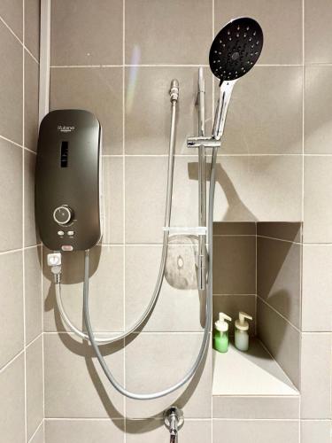 a shower with a shower head in a bathroom at Alinea Suites by Moka in Shah Alam