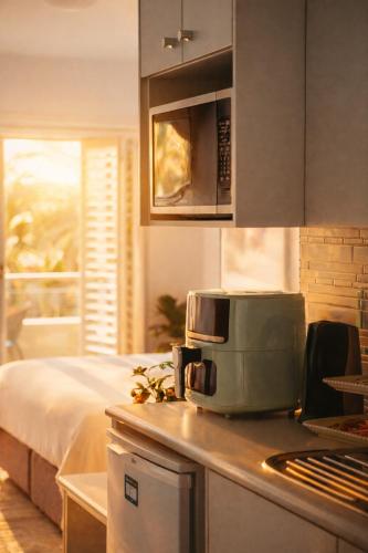 a kitchen with a coffee maker on a counter at Beautifully Restyled Studio Apartment - Oaks Pacific Blue - Sea Salt Escape in Salamander Bay