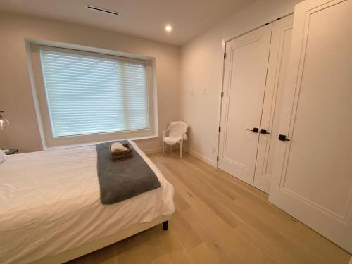 a bedroom with a bed and a window and a chair at 温哥华温西别墅民宿47 in Vancouver