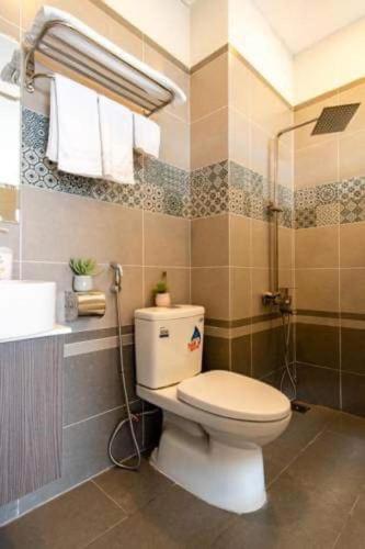 a bathroom with a toilet and a shower at The Shann Hotel Danang in Danang