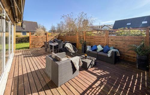a patio with couches and tables on a wooden deck at 4 Bedroom Cozy Home In Allinge in Allinge
