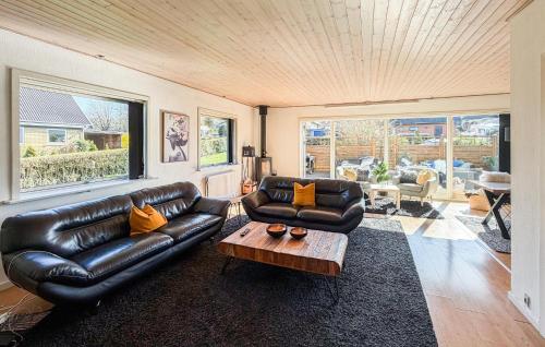a living room with a leather couch and a coffee table at 4 Bedroom Cozy Home In Allinge in Allinge