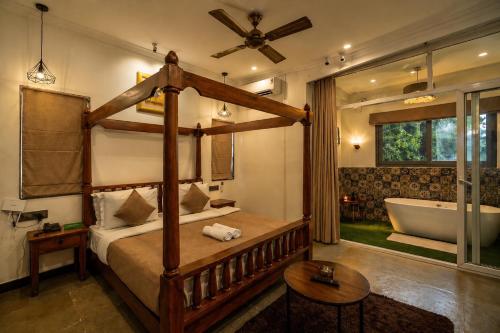 a bedroom with a bed and a tub in a room at Dimaru Boutique Hotel in Calangute