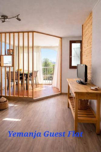 a living room with a dining table and a tv at Yemanja Guest Flat- vue Mer &Salin, piscine, climatisation in Gruissan