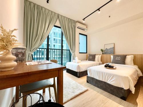 a hotel room with two beds and a desk at Alinea Suites by Moka in Shah Alam