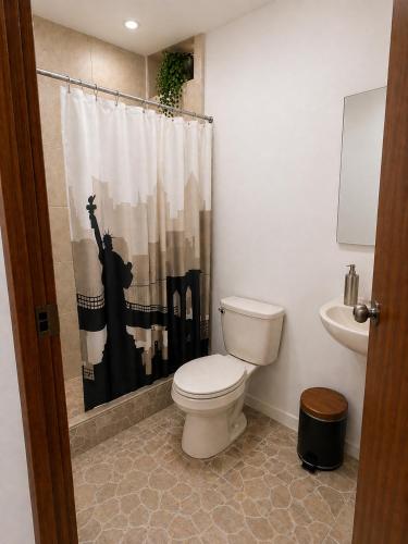 a bathroom with a toilet and a shower curtain at Hospedaje Cocos House Talara - amplias habitaciones, Buena Ubicacion in Talara