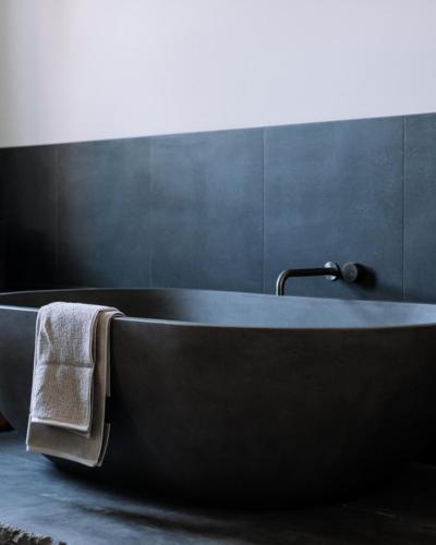a bath tub with a towel on it in a bathroom at The Benev - Wellness Accommodation in Beechworth