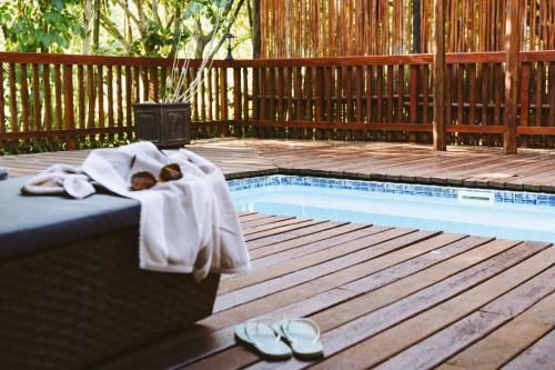 a teddy bear laying on a towel next to a pool at Monzi Safari Lodge in Monzi