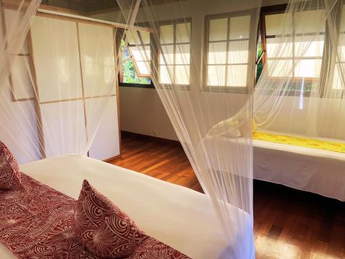 a bedroom with two beds with mosquito nets at Fare Oviri Lodge in Opoa