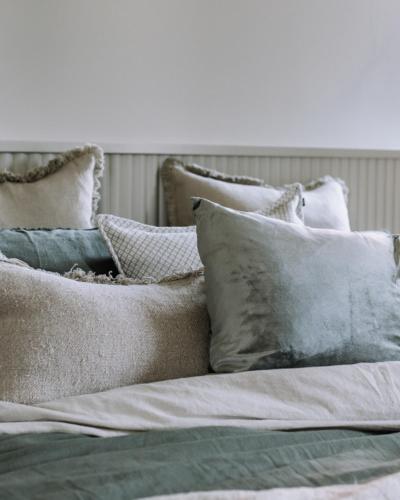 a pile of pillows sitting on top of a bed at The Benev - Wellness Accommodation in Beechworth