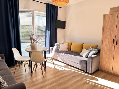 a living room with a couch and a table at Piaskowy 2 in Jantar