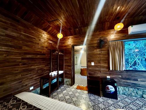 a bathroom with wooden walls and a room with a sink at Cham Trang An Retreat in Vũ Lâm