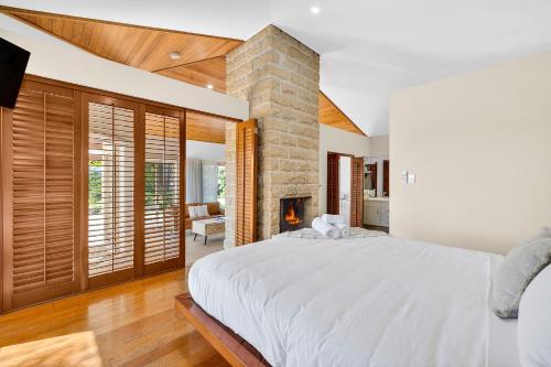 a bedroom with a large bed and a stone fireplace at Summergrove Estate in Carool