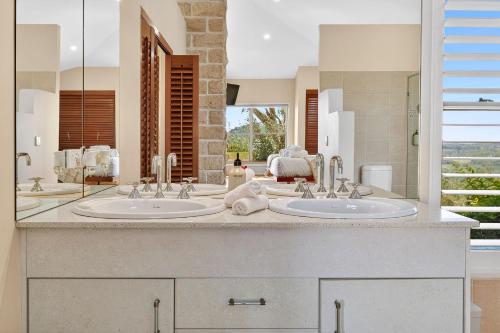 a bathroom with two sinks and a large mirror at Summergrove Estate in Carool