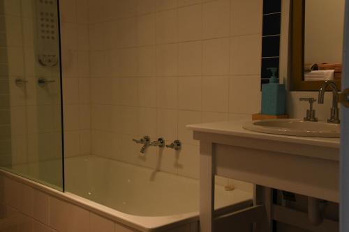 a bathroom with a shower and a tub and a sink at Neerim Country Cottages in Neerim South