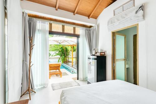 a bedroom with a bed and a view of the pool at Tewana Home Phuket in Phuket