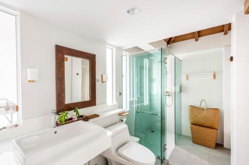a bathroom with a toilet and a glass shower at Tewana Home Phuket in Phuket