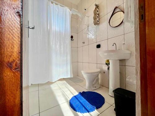 a bathroom with a white toilet and a sink at A Casa di Minas in Três Corações