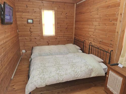 a bedroom with a bed in a wooden cabin at Lassy Condominium in Nishiharamura