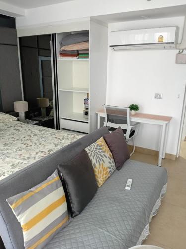a living room with a couch and a desk at Central Pattaya Apartments in Pattaya