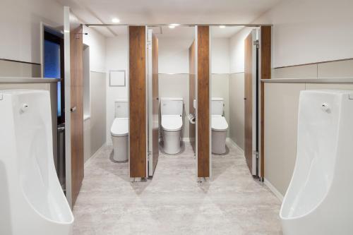 a bathroom with two toilets and two sinks at commun SHIBUYA (Male Only) in Tokyo