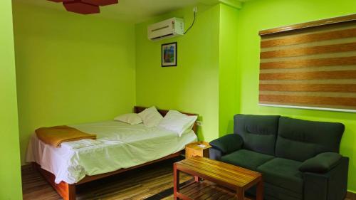 a green bedroom with a bed and a couch at SPATHODEA in Vagamon