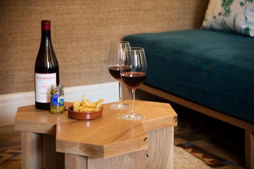 two glasses of wine and chips on a wooden table at Hotel Casa Bonay & Spa in Barcelona