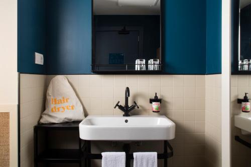 La salle de bains est pourvue d'un lavabo blanc et d'un miroir. dans l'établissement Hotel Casa Bonay, à Barcelone