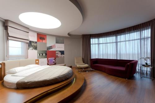 a bedroom with a large bed and a red couch at Orucoglu Oreko Hotel in Manisa