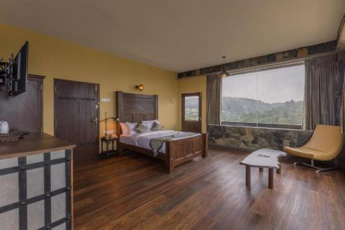 a bedroom with a bed and a large window at Fort WindShire in Nuwara Eliya