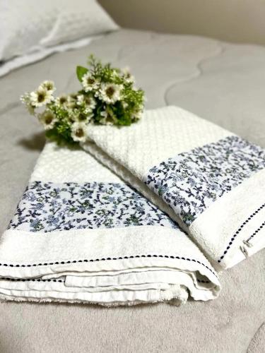 a couple of towels with flowers on a bed at Hotel Serrano in Inácio Martins