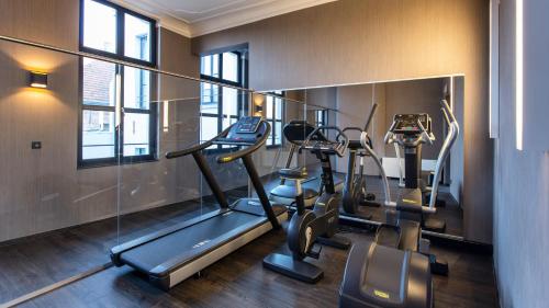 a gym with three tread machines in a room at Hotel Harmony in Ghent