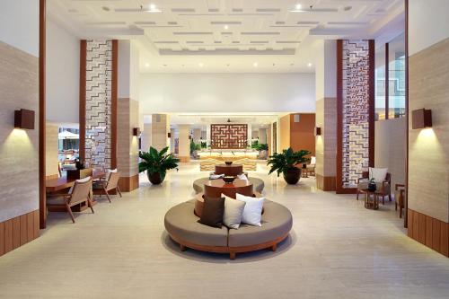a lobby with a couch in the middle of a room at The Bandha Hotel & Suites in Legian