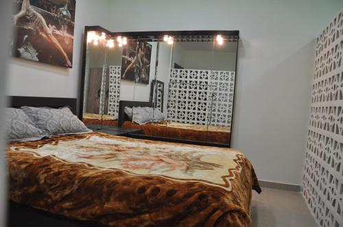 a bedroom with a large bed and a mirror at Isramax Jerusalem Apartment in Bat-Yam in Bat Yam