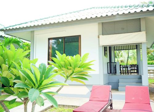 a house with two pink chairs in front of it at Lamai Inn 99 Bungalows in Lamai
