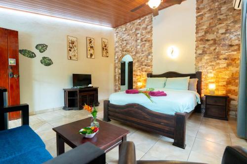 a bedroom with a bed and a living room at Casa Caribbean Coconut in Cahuita