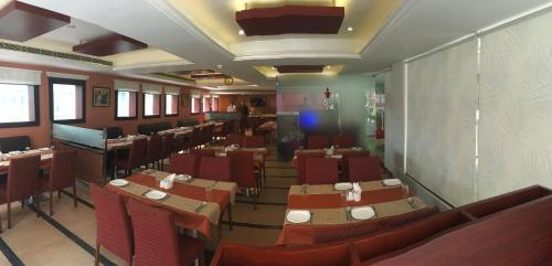 a restaurant with tables and chairs in a room at Cochin Palace in Cochin