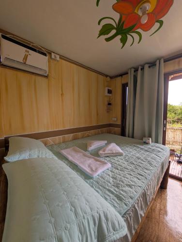 a bedroom with a bed with two towels on it at Jadens Guesthouse in Siquijor