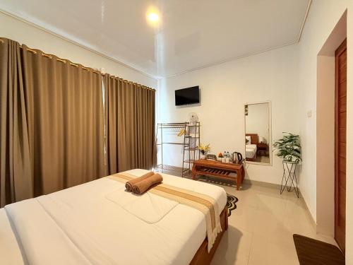 a bedroom with a bed and a mirror at The Angga House in Bangli